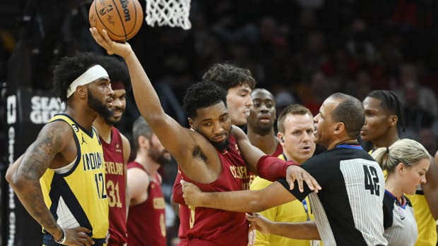 Cleveland Cavaliers guard Donovan Mitchell (45) holds the ball away from referee Eric Lewis (42) after a jump ball was called during the second half against the Indiana Pacers at Rocket Mortgage FieldHouse.