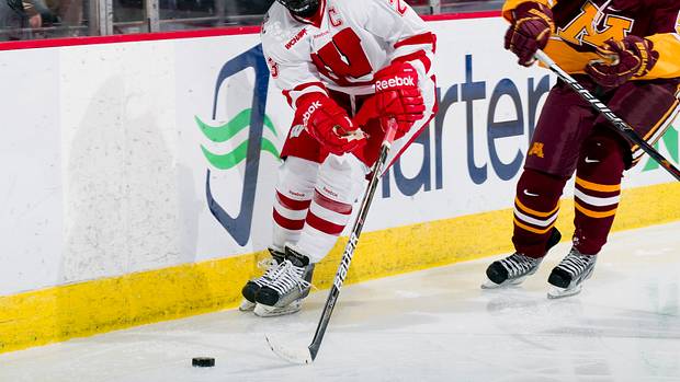 Women's hockey star Hilary Knight skating maneuvering down the ice against Minnesota