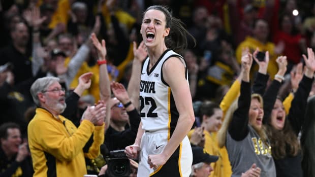 Iowa Hawkeyes guard Caitlin Clark (22) reacts with fans after breaking the NCAA women's all-time scoring record during the first quarter against the Michigan Wolverines.