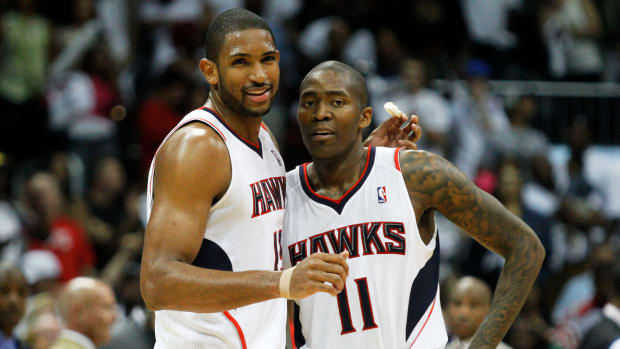 Atlanta Hawks center Al Horford (15) hugs teammate guard Jamal Crawford (11) in the final seconds of the game against the Chicago Bulls at Philips Arena. The Hawks won 100-88.