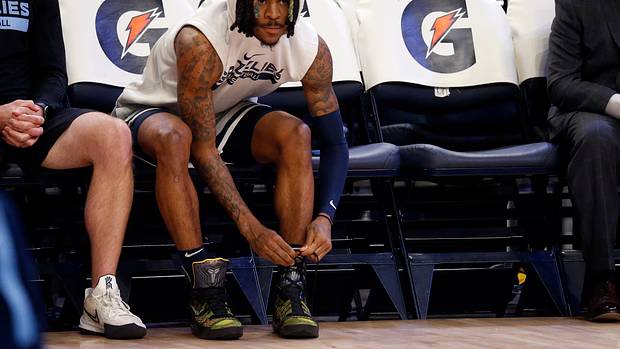 Grizzlies guard Ja Morant ties his shoes during warmups.