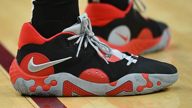 View of black, red, and grey Nike PG shoes.