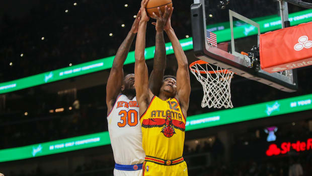 New York Knicks forward Julius Randle (30) and Atlanta Hawks forward De'Andre Hunter (12) reach for a rebound.