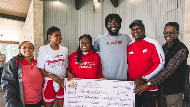 Wisconsin linebacker Jordan Turner presenting a check of $2,000 he donated to The Road Home (Credit: Troy Beckman, Team IFA)