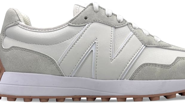 Side view of a white and grey New Balance golf shoe.