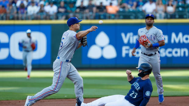 Jul 25, 2022; Seattle, Washington, USA; Texas Rangers shortstop Corey Seager (5) throws to first base for a double play against Seattle Mariners first baseman Ty France (23) during the first inning at T-Mobile Park. Mandatory Credit: Joe Nicholson-USA TODAY Sports