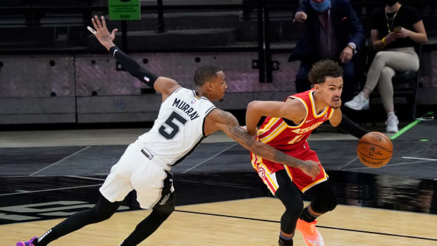 Atlanta Hawks guard Trae Young (11) dribbles up court as San Antonio Spurs guard Dejounte Murray (5) reaches in for a foul in the fourth quarter at AT&T Center.