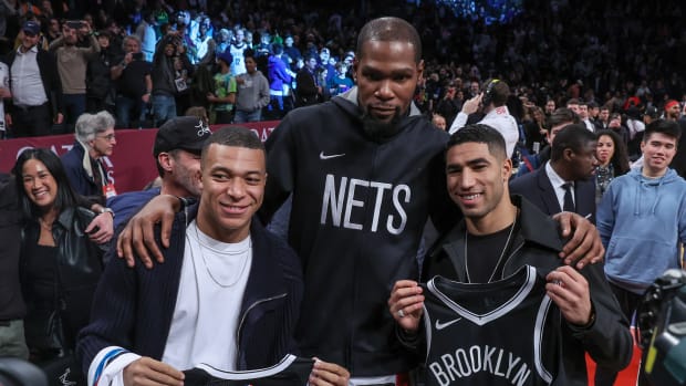 Kylian Mbappe and Achraf Hakimi pose for a photo with Kevin Durant.