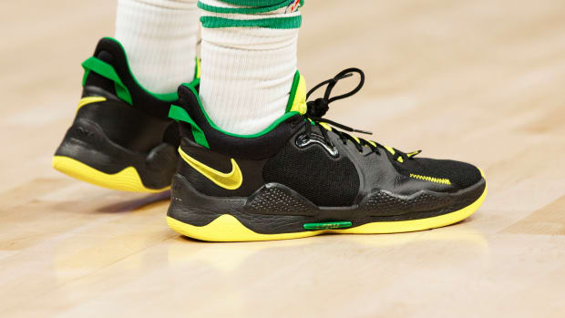 View of black, yellow, and green Nike shoes.