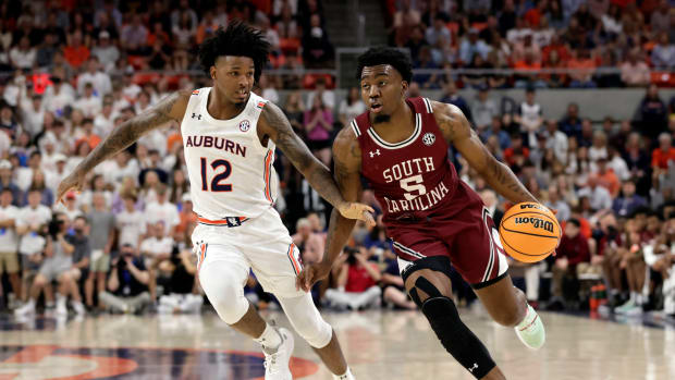 South Carolina guard Jermaine Couisnard (5) dribbles around Auburn guard Zep Jasper (12) as he goes to the basket during the first half of an NCAA college basketball game Saturday, March 5, 2022, in Auburn, Ala. (AP Photo/Butch Dill)