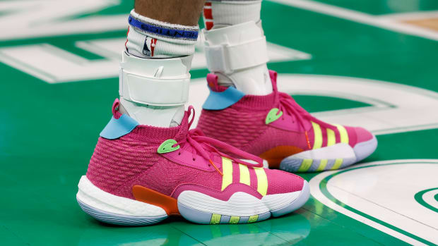 View of Trae Young's pink and yellow adidas shoes.