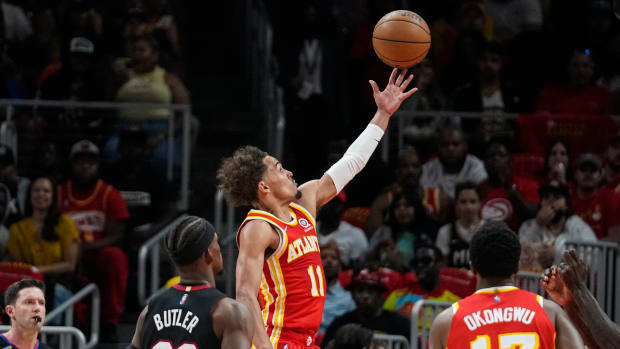 Apr 22, 2022; Atlanta, Georgia, USA; Atlanta Hawks guard Trae Young (11) scores a basket behind Miami Heat forward Jimmy Butler (22) during the first half of game three of the first round for the 2022 NBA playoffs at State Farm Arena.