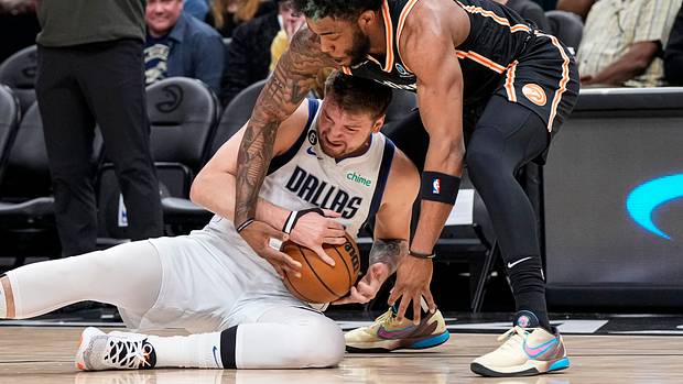Dallas Mavericks guard Luka Doncic and Atlanta Hawks forward Saddiq Bey fight for a loose ball.