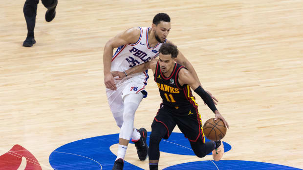 Trae Young dribbles past Ben Simmons.