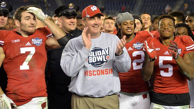 Paul Chryst smiling with players after winning the Holiday Bowl.