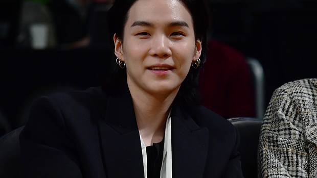 Suga smiles for a picture.
