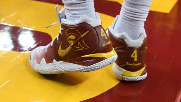 View of cardinal and gold Nike Kyrie shoes.
