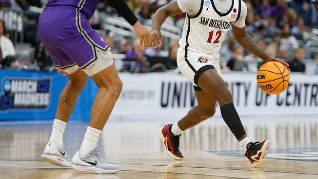 San Diego State Aztecs guard Darrion Trammell dribbles against Furman Paladins guard Mike Bothwell.
