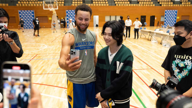Stephen Curry takes a selfie with Suga.