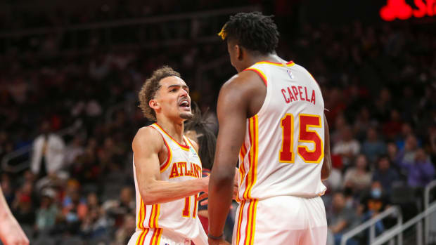 Mar 31, 2022; Atlanta, Georgia, USA; Atlanta Hawks guard Trae Young (11) and center Clint Capela (15) celebrate after an alley oop against the Cleveland Cavaliers in the second half at State Farm Arena.