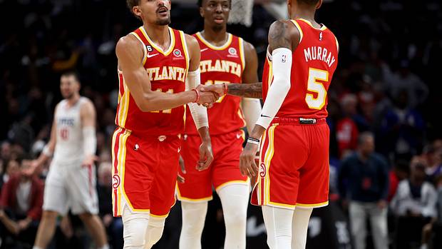 Trae Young, Dejounte Murray, and Onyeka Okongwu walk off the court.
