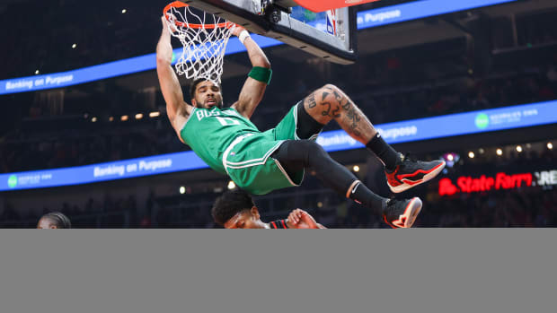 Boston Celtics forward Jayson Tatum dunks over Atlanta Hawks forward De'Andre Hunter.