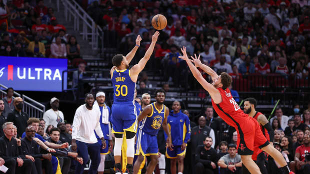 Warriors guard Stephen Curry shoots the ball as Houston Rockets center Alperen Sengun defends during the fourth quarter at Toyota Center.