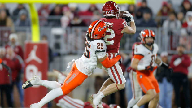 Oklahoma's Drake Stoops (12) catches a pass beside Oklahoma State's Jason Taylor II (25) during a Bedlam college football game between the University of Oklahoma Sooners (OU) and the Oklahoma State University Cowboys (OSU) at Gaylord Family-Oklahoma Memorial Stadium in Norman, Okla., Saturday, Nov. 19, 2022. Bedlam Football
