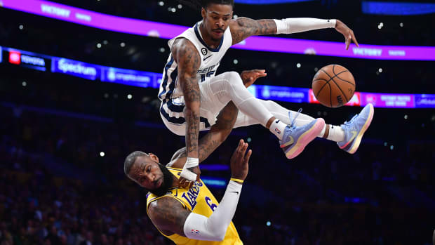 Memphis Grizzlies guard Ja Morant jumps over Los Angeles Lakers forward LeBron James.