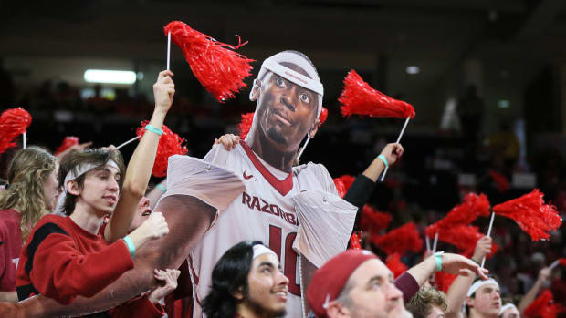 Arkansas fans get into the spirt of Bobby Portis night with a cut-out puppet wearing the Bobby Portis head band given away at the game while also waiving the pom-poms they received for the red-out.