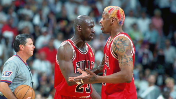 Chicago Bulls forward DENNIS RODMAN is held back from the official by guard MICHAEL JORDAN