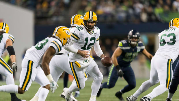 Green Bay Packers quarterback Aaron Rodgers hands the ball off to running back Aaron Jones.