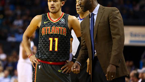 Hawks guard Trae Young talks with head coach Lloyd Pierce during a timeout.