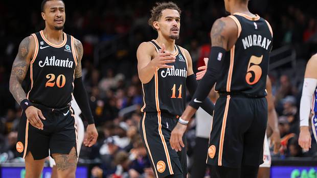 John Collins, Trae Young, and Dejounte Murray celebrate a play.
