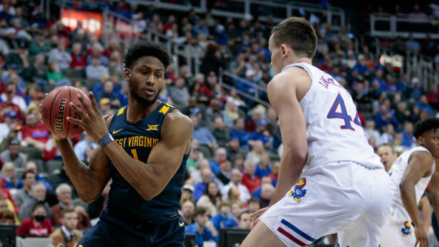 Mar 10, 2022; Kansas City, MO, USA; West Virginia Mountaineers forward Pauly Paulicap (1) looks to get around Kansas Jayhawks forward Mitch Lightfoot (44) during the second half at T-Mobile Center. Mandatory Credit: William Purnell-USA TODAY Sports
