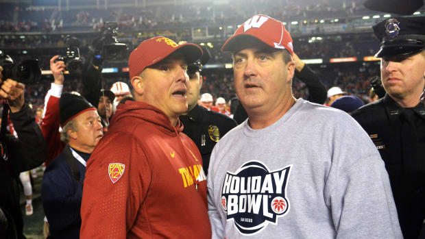Paul Chryst speaking with USC head coach Clay Helton after the Holiday Bowl.