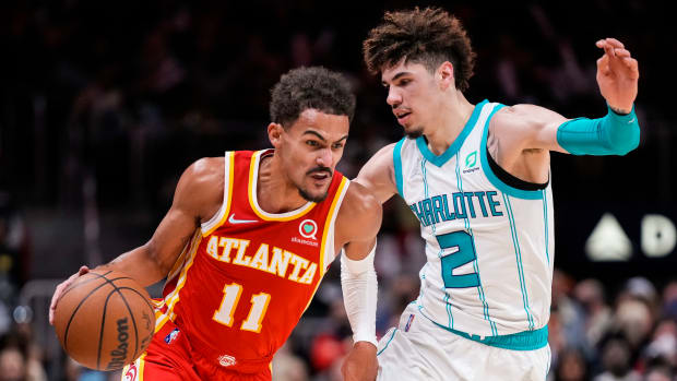 Hawks guard Trae Young dribbles the ball against Hornets guard LaMelo Ball.