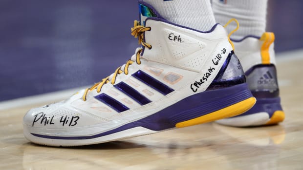View of white and purple adidas shoes.