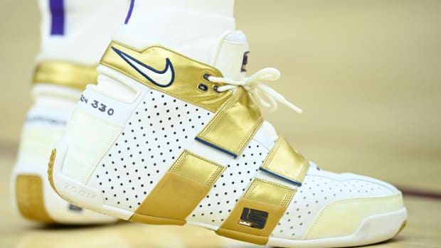 View of the white and gold Nike LeBron '20-5-5' shoes.