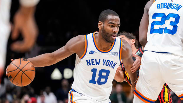 Knicks guard Alec Burks dribbles past Hawks guard Trae Young.