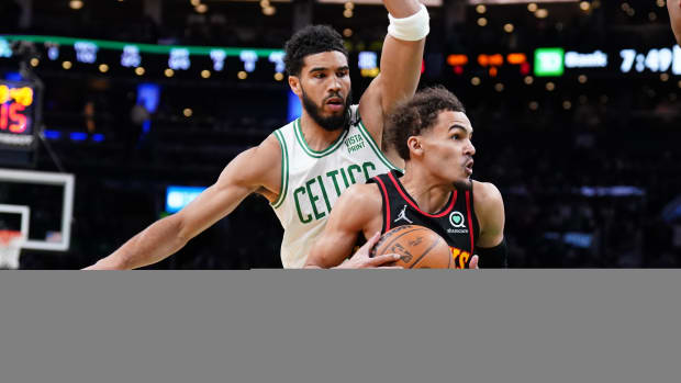Atlanta Hawks guard Trae Young dribbles past Boston Celtics forward Jayson Tatum.