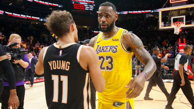 Lakers forward LeBron James talks to Hawks guard Trae Young.