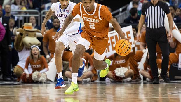 Texas Longhorns guard Arterio Morris (2) handles the ball while being chased by Kansas Jayhawks guard Dajuan Harris Jr. (3) in the first half at T-Mobile Center.