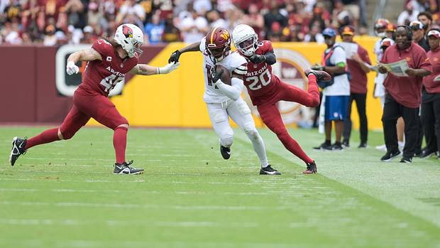 Washington Commanders wide receiver Terry McLaurin (17) cuts in-between Arizona Cardinals linebacker Dennis Gardeck (45) and cornerback Marco Wilson (20) as assistant head coach/offensive coordinator Eric Bieniemy look on during the first half at FedExField.
