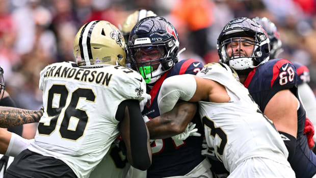 Saints defensive tackles and cornerback wrap up Houston Texans running back Dameon Pierce during the first quarter at NRG Stadium.