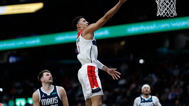 Washington Wizards guard Johnny Davis (1) shoots the ball as Dallas Mavericks guard Luka Doncic (77) looks on in the fourth quarter at Capital One Arena.
