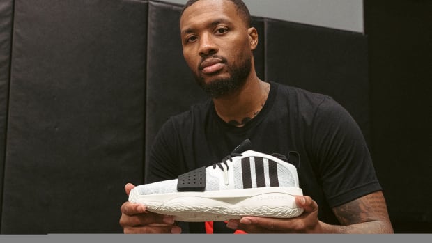 Damian Lillard poses with his white and black adidas shoe.