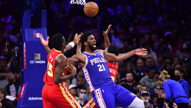 76ers center Joel Embiid reacts as he collides with Hawks center Clint Capela.