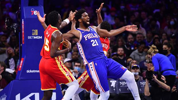 76ers center Joel Embiid reacts as he collides with Hawks center Clint Capela.