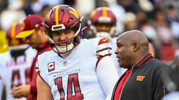Washington Commanders quarterback Sam Howell (14) talks with Washington Commanders offensive coordinator Eric Bieniemy before the game against the Dallas Cowboys at FedExField. Mandatory Credit: Brad Mills-USA TODAY Sports